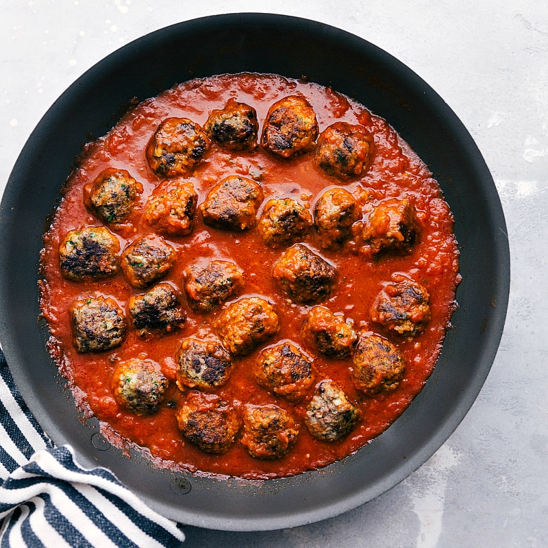 Process shot-- Image of the meatballs simmering in the marinara sauce.