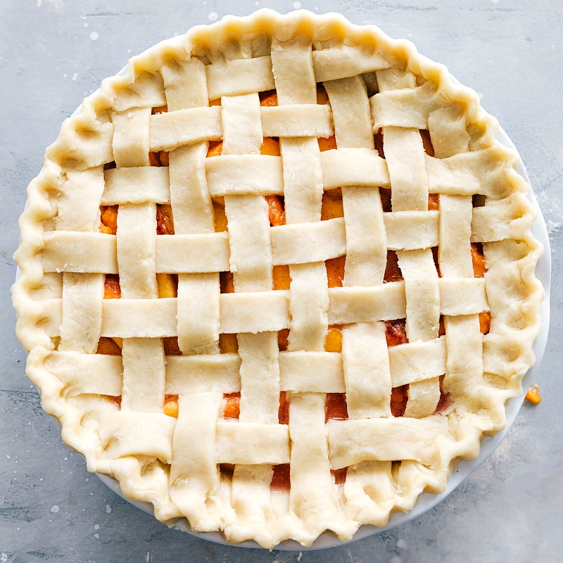 Process shot-- Image of the uncooked pie with the pie crust on top, ready to be baked.