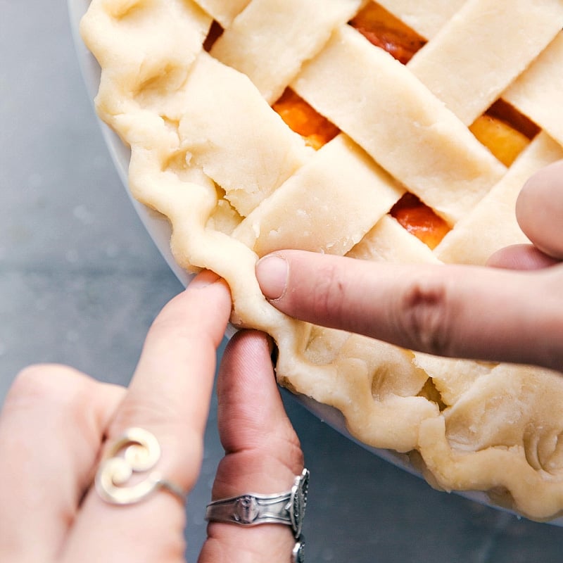 The crust's edge being shaped into a beautiful pattern, adding an artistic touch.