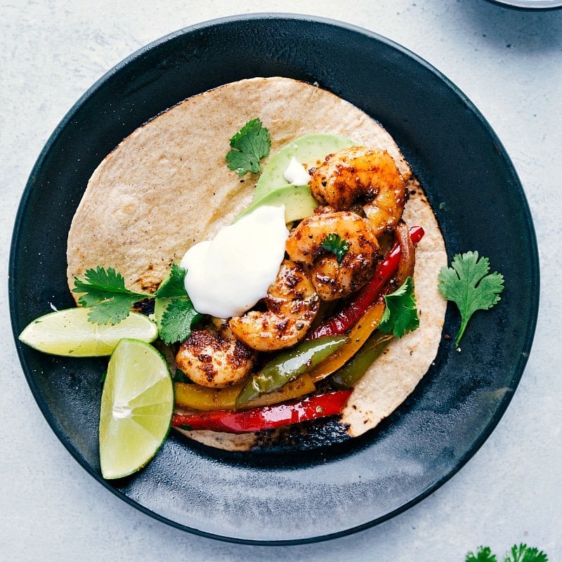 Overhead image of Shrimp Fajitas in a tortilla, with all the toppings, ready to eat.