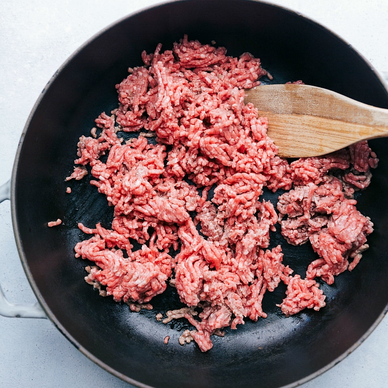 Ground beef being cooked on a skillet, a crucial step in this recipe.