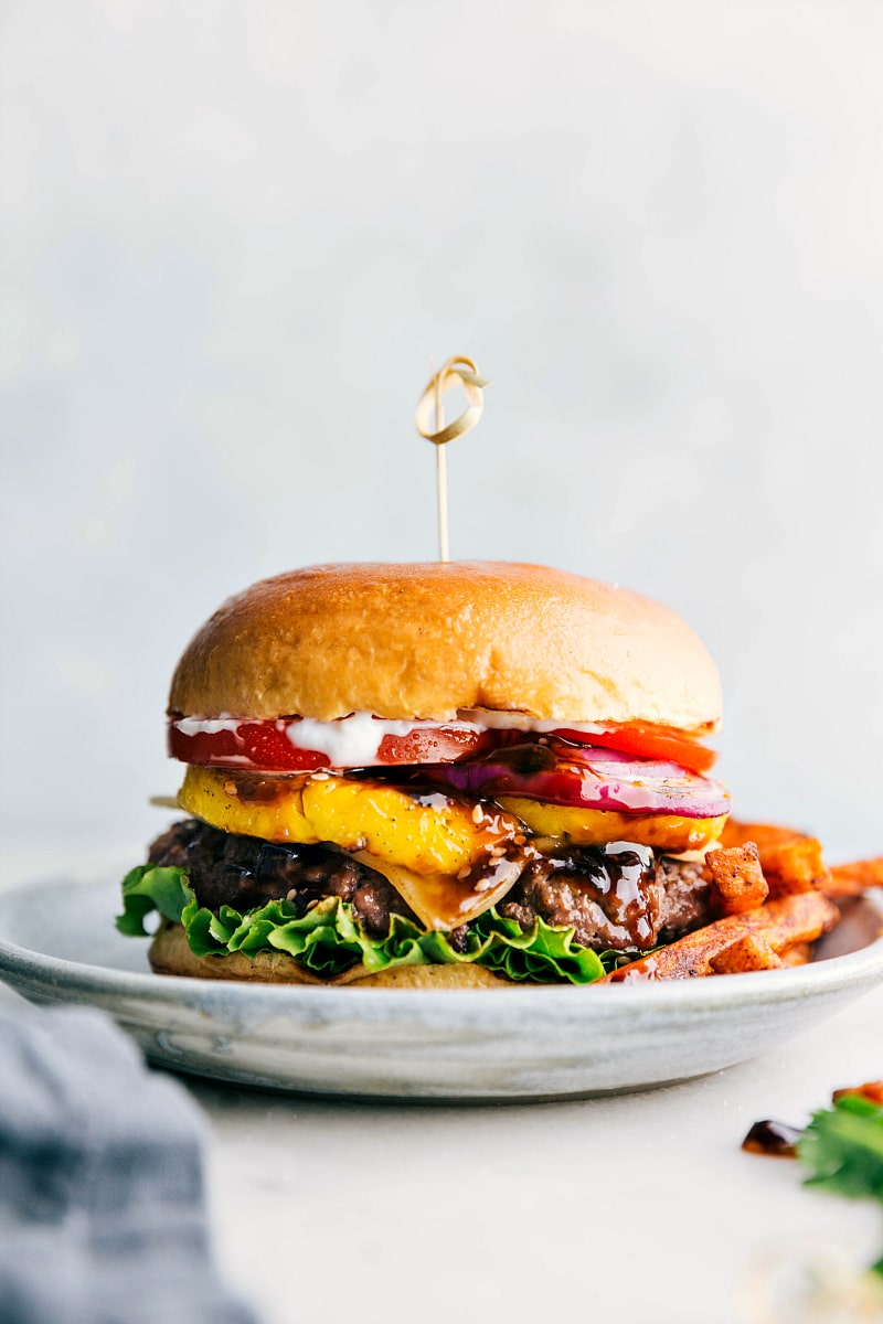 Ready to eat delicious and flavor-packed teriyaki burger, complete with all its toppings between a buttery bun and fries on the side.