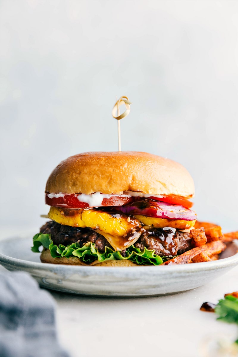 Delicious Teriyaki Burger with Toppings and Fries - Ready to Savor Ready to eat delicious and flavor-packed teriyaki burger, complete with all its toppings between a buttery bun and fries on the side.