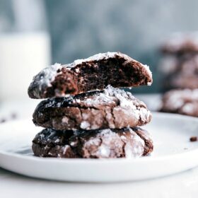 The finished chocolate crinkle cookie recipe, with cookies stacked and split to reveal their soft, gooey interiors.