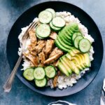 Apricot chicken in a bowl with rice, avocado, and cucumbers, a delicious and balanced meal.