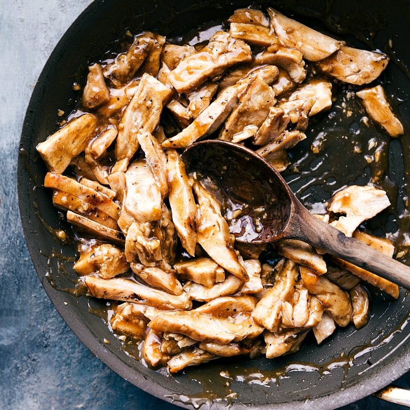 Cooked meat covered in the sauce, still in the saucepan.