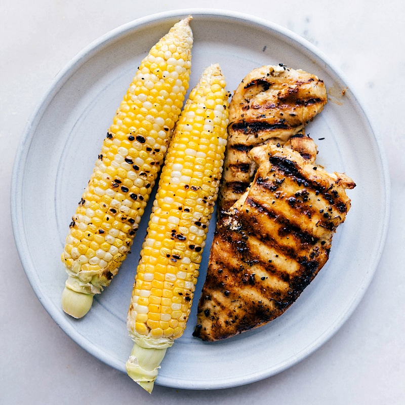 Overhead image of the corn and chicken on a plate, freshly grilled.