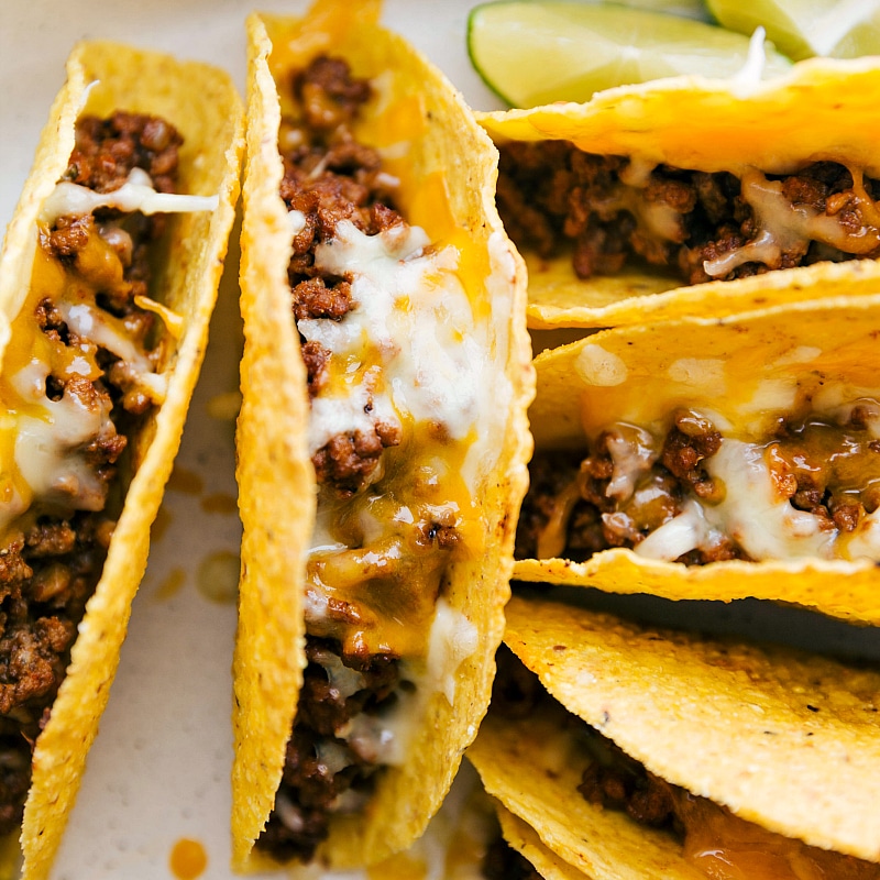 Ground beef tacos fresh out of the oven, topped with melty cheese, hot and ready to be served.