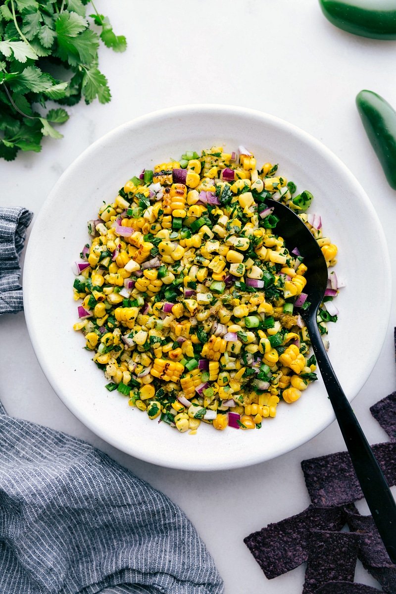 Overhead image of Corn Salsa in a bowl with a spoon on the side.