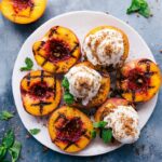 Grilled peaches with ice cream and fresh mint on top - a sweet and fruity treat.