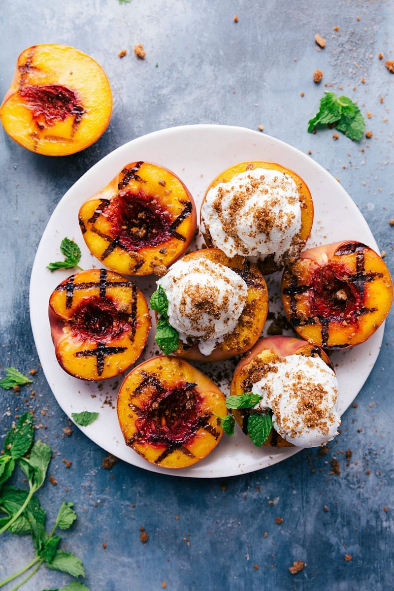 Overhead image of Grilled Peaches on a plate with ice cream and fresh mint on top.