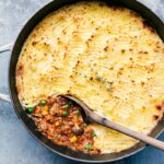 Shepherd's pie vegetarian variation still in the pot with a wooden spoon in it.