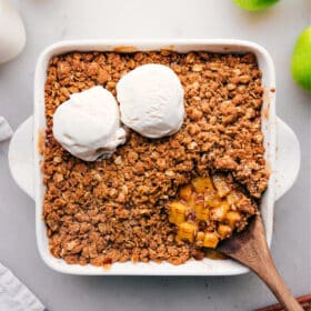 Overhead view of a golden-brown apple crumble in a dish.