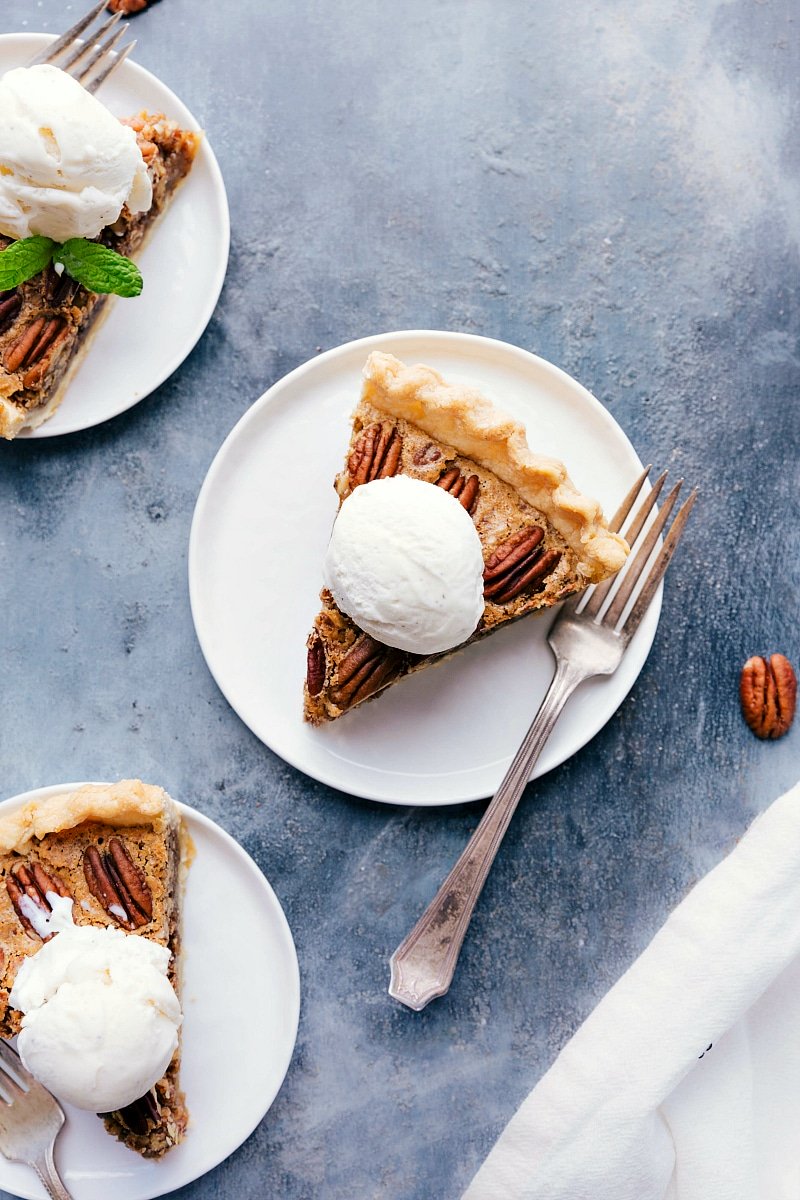 Overhead image of Pecan Pie slices with ice cream on top, fresh mint, and a fork on the side.