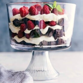 A stunning brownie trifle displaying layers of brownies, fresh fruit, and luscious cream filling, all set and inviting.