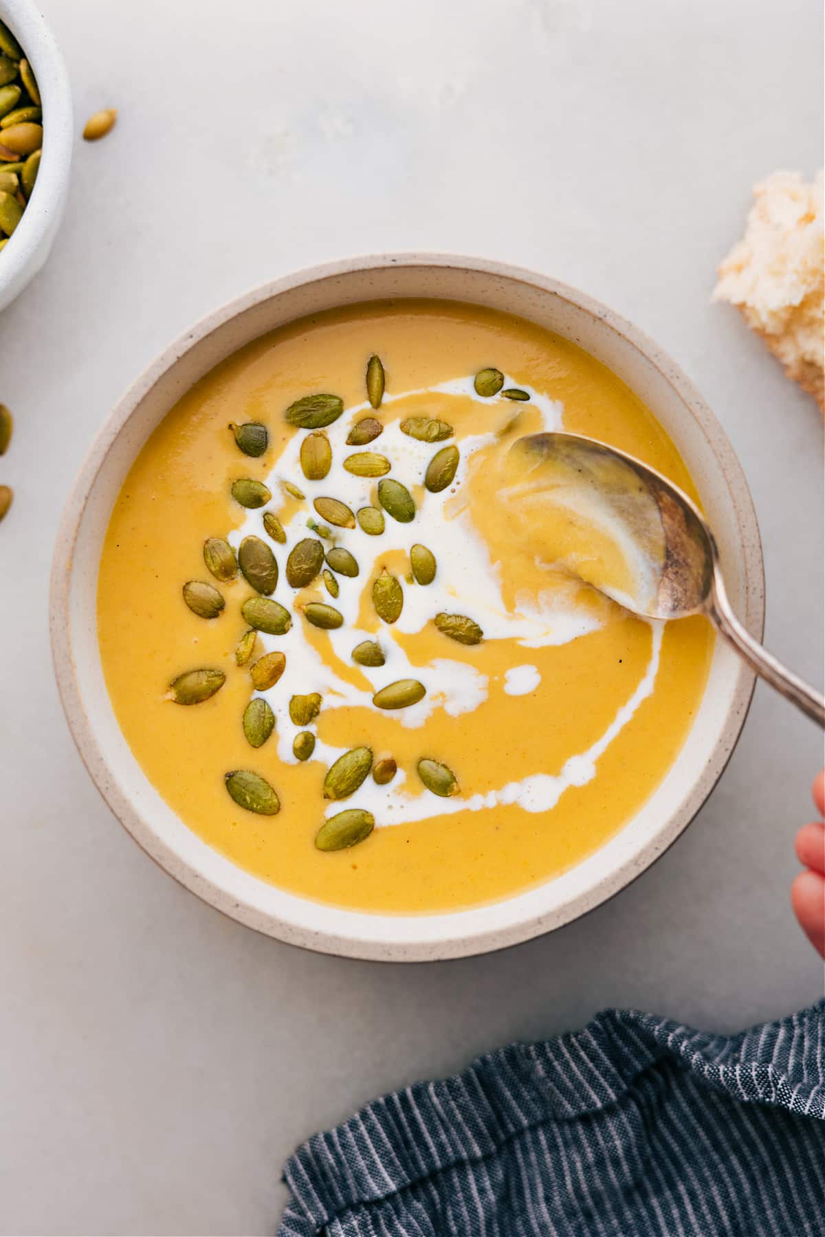 The Best Butternut Squash Soup Recipe Butternut squash soup in a bowl topped with pepitas.