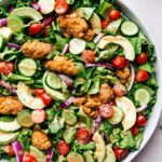 Crispy chicken salad in a bowl, dressed and ready to eat, offering a delicious and satisfying meal.