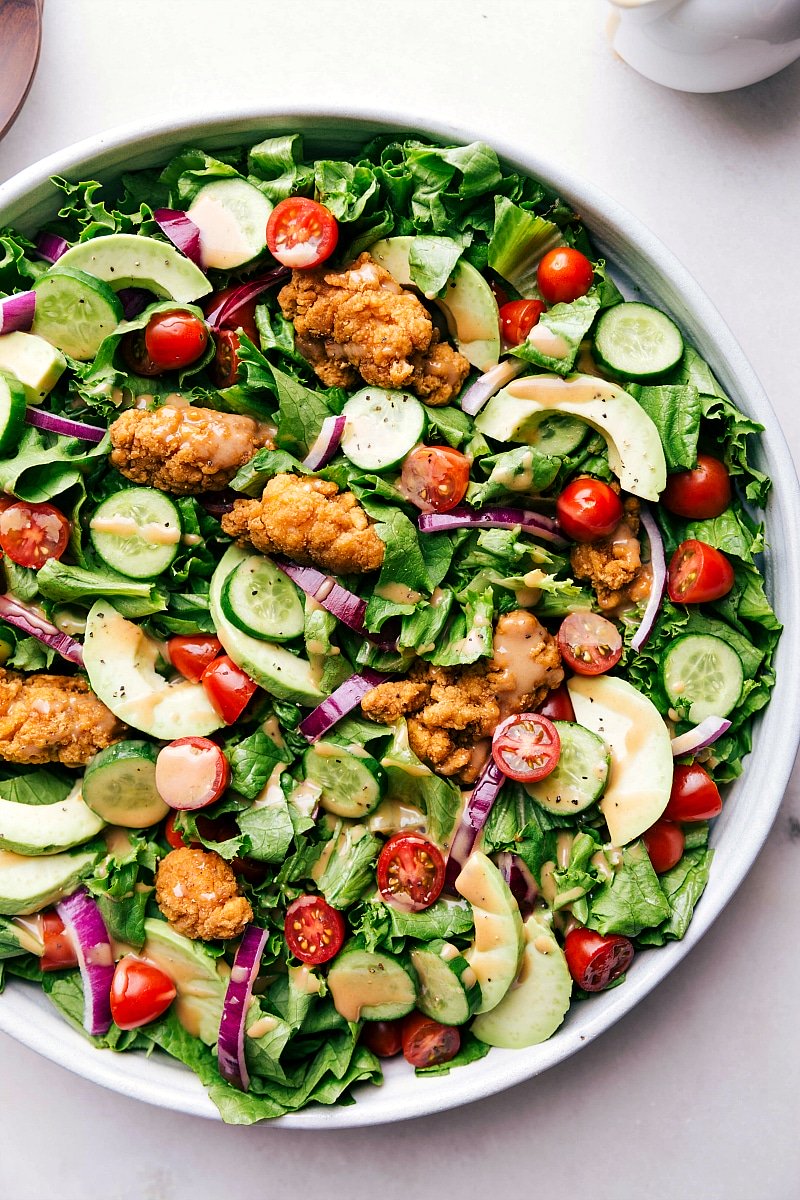 Crispy chicken salad in a bowl, dressed and ready to eat, offering a delicious and satisfying meal.