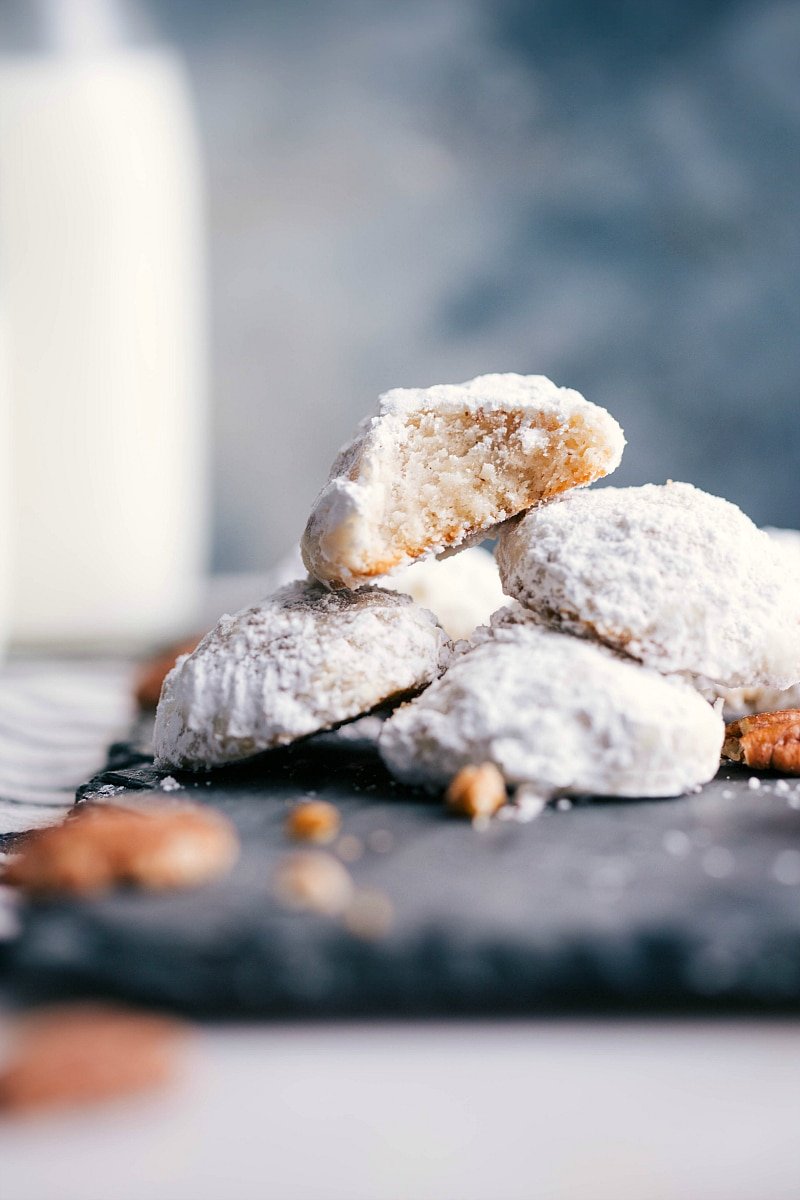 Image of Mexican Wedding Cookies stacked on top of each other, with a bite taken out of one of them.