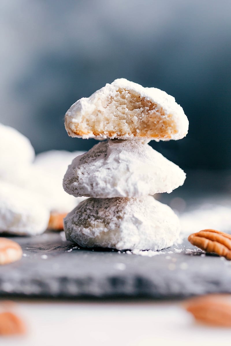 Image of three Mexican Wedding Cookies stacked on top of each other, with a bite out of the top one.