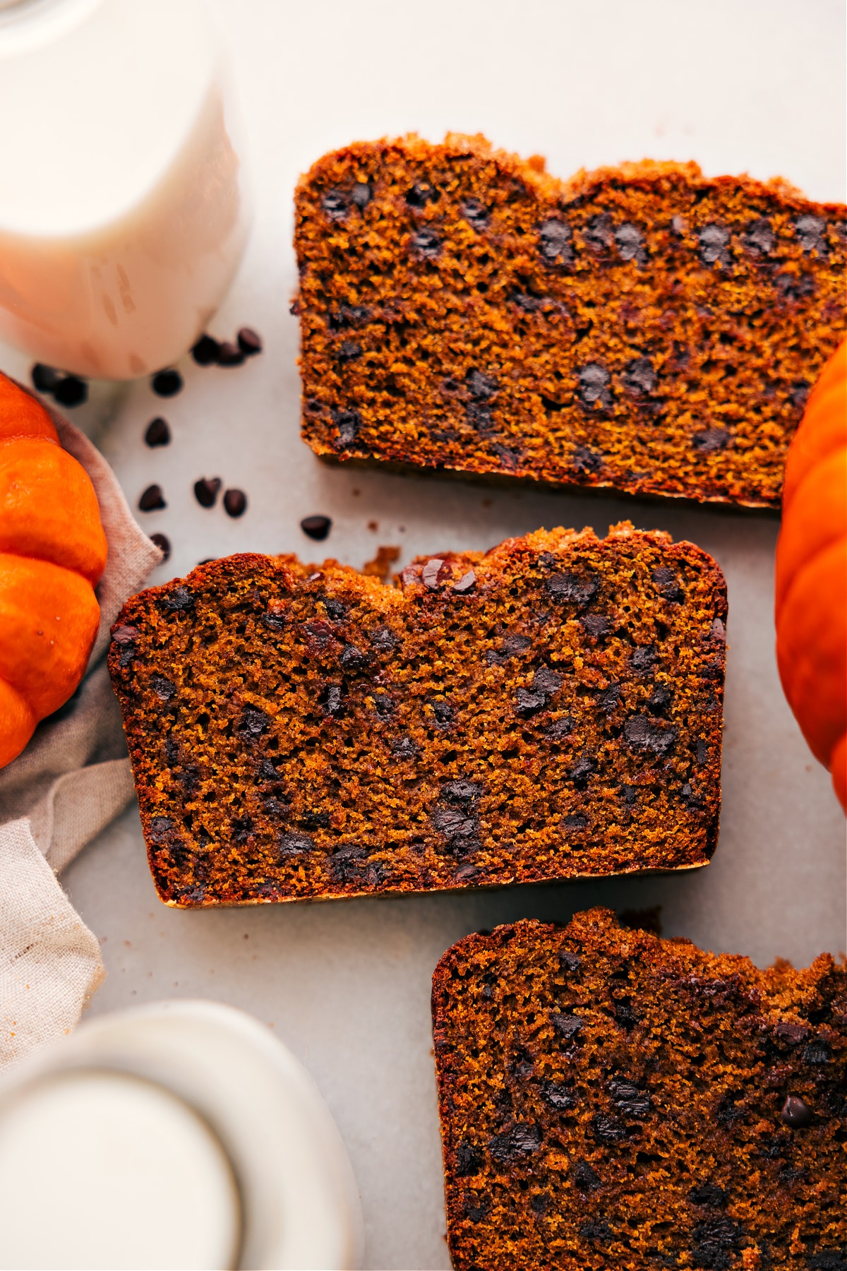 Three slices of chocolate chip pumpkin bread showcasing their delicious interior with scattered chocolate chips.