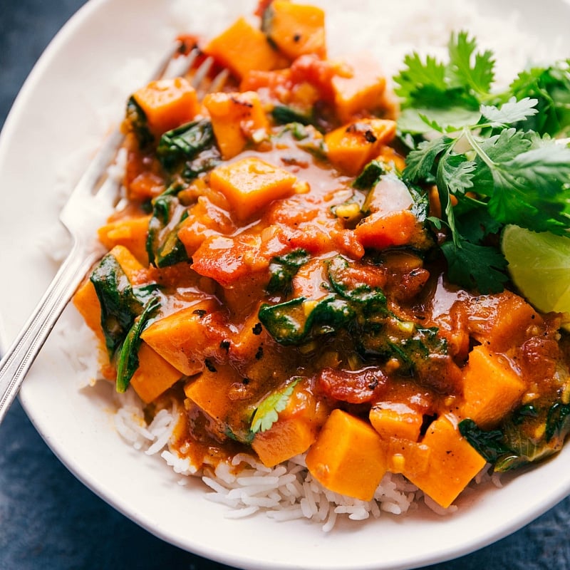 The finished sweet potato curry recipe in a bowl, over a bed of rice, ready to be eaten.