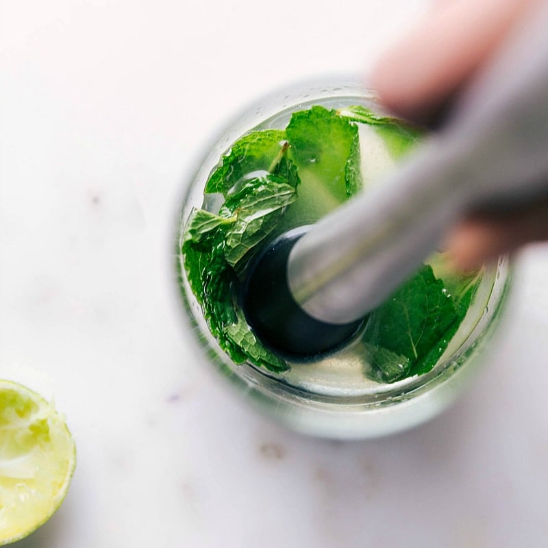 Process shot-- Image of the mint leaves for this Virgin Mojito being muddled.