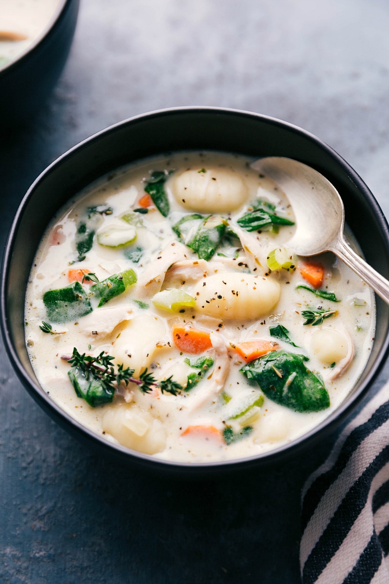 Image of a bowl of Chicken Gnocchi Soup with a spoon in it, ready to be eaten.