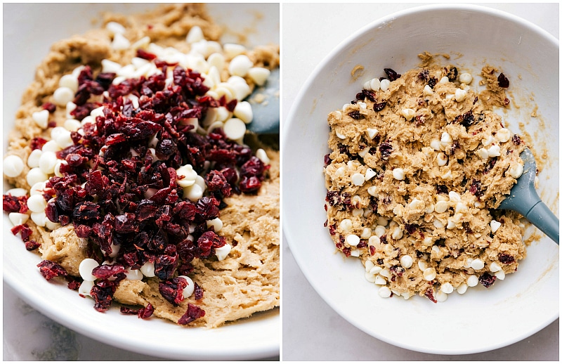 Stirring in cranberries and white chocolate chips into the cranberry oatmeal cookie dough for a final mix.