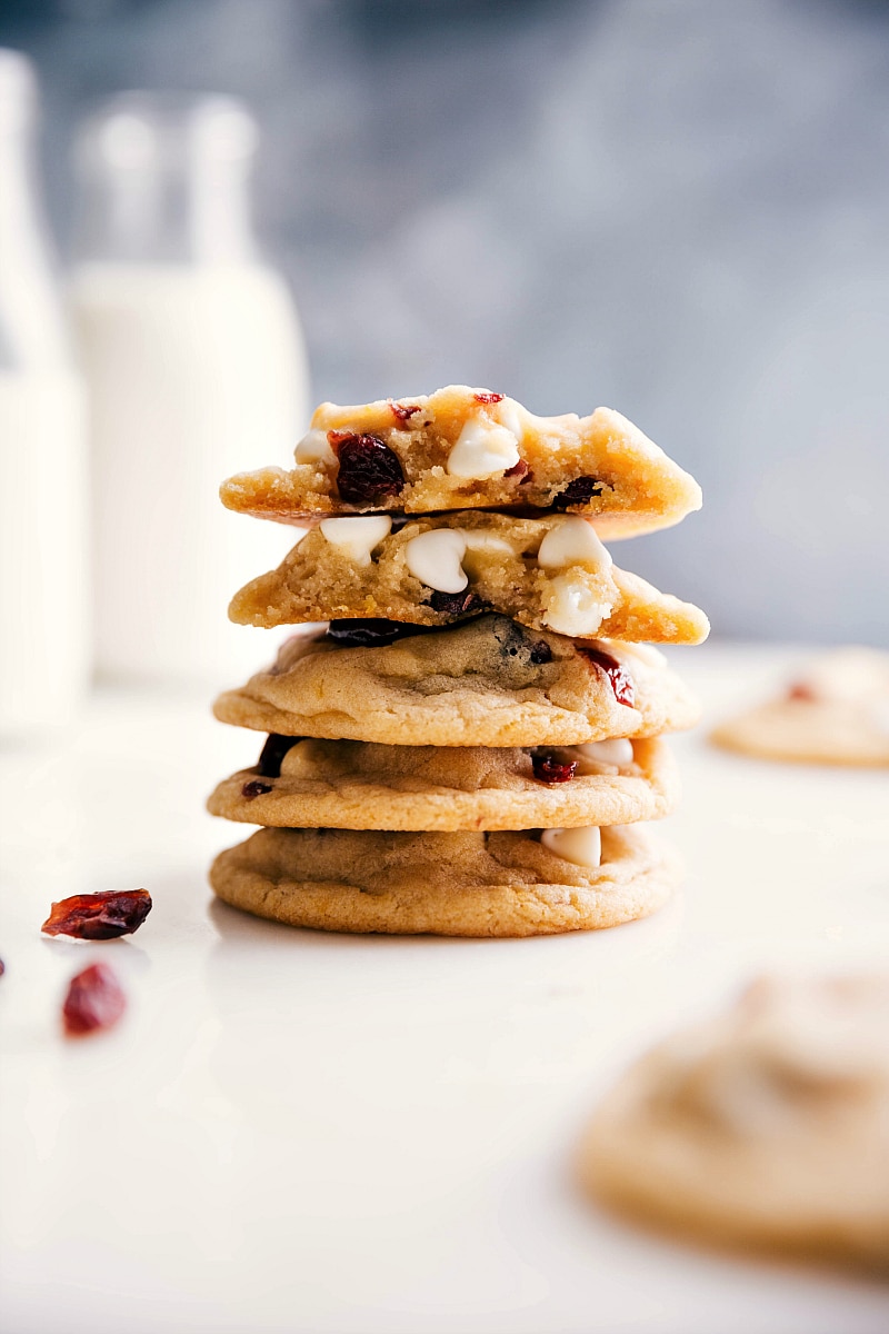 Stack of white chocolate cranberry cookies split open, revealing a gooey, warm interior with melted white chocolate and cranberries.