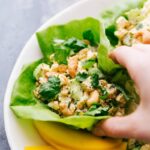 A vibrant and appetizing curry chicken salad nestled in a crisp lettuce wrap, bursting with colors and flavors, ready for a healthy bite.