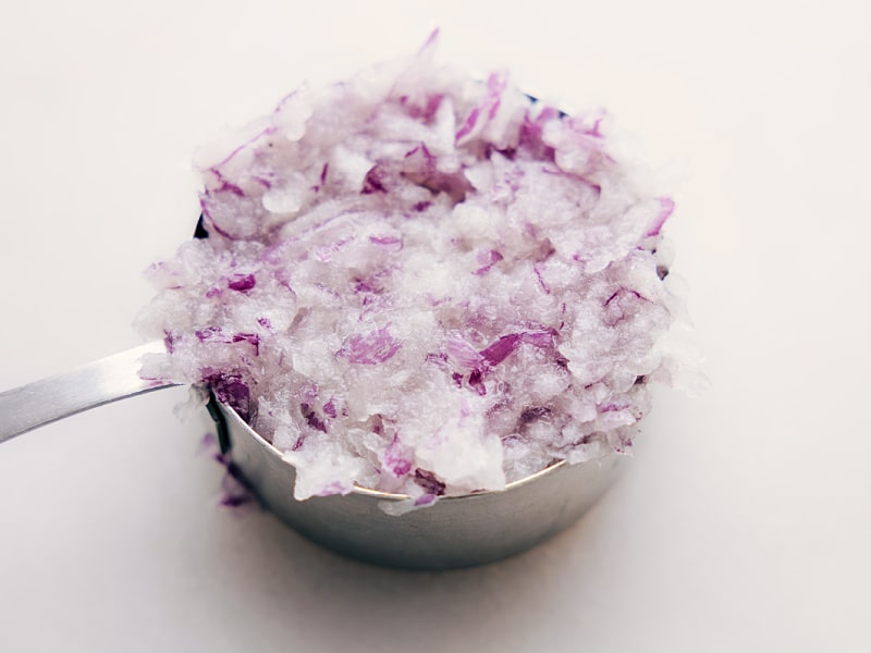 Image of a measuring cup filled with the grated onion