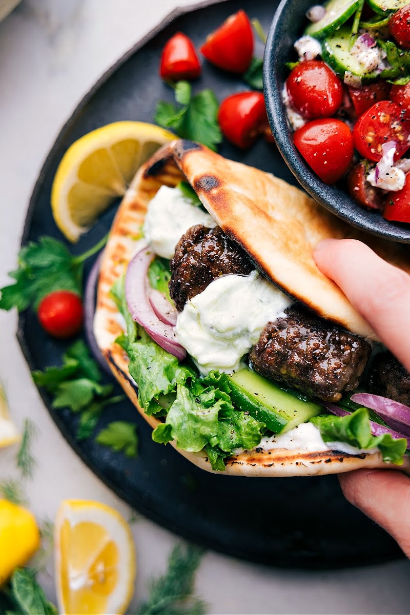 Up-close image of the Greek Meatballs in a pita with all the toppings ready to be enjoyed