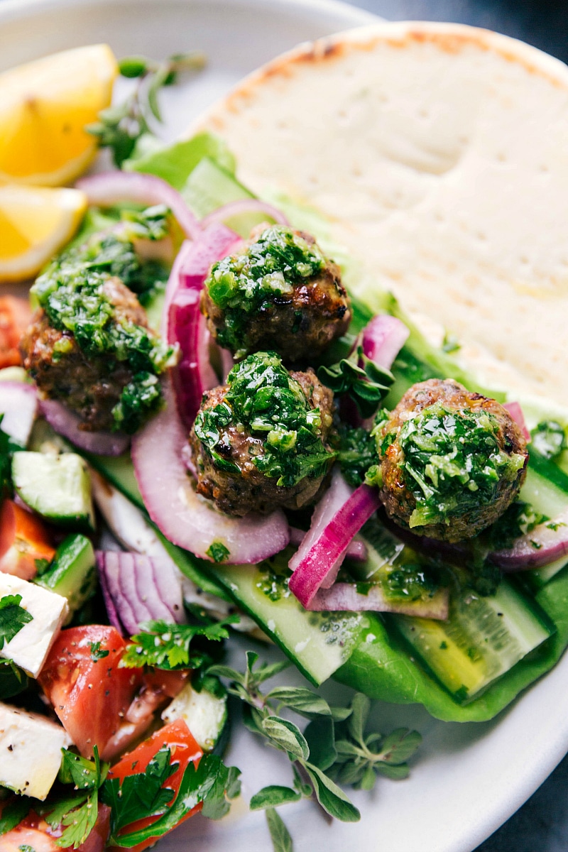 Overhead image of Greek Meatballs in a pita with toppings and the fresh sauce.