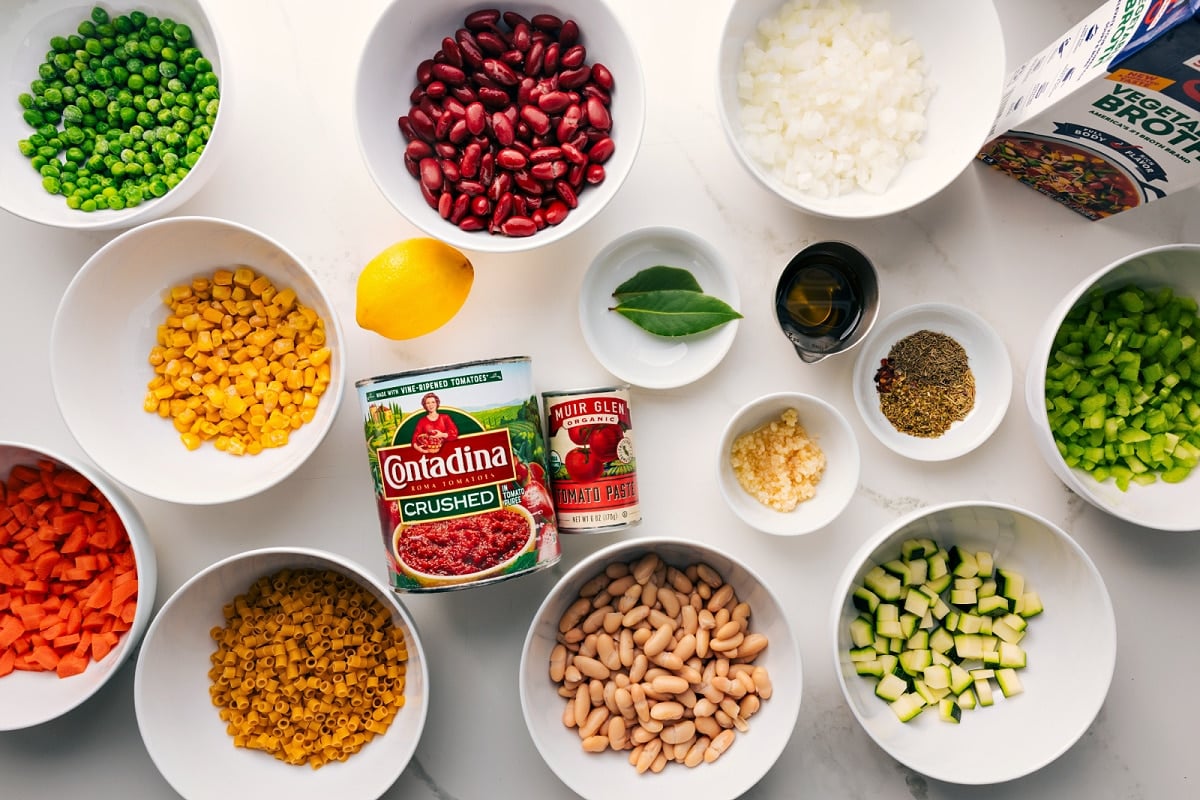 How To Make Olive Garden Minestrone Soup Recipe Ingredients prepped for easy assembly, including peas, beans, pasta, crushed tomatoes, tomato paste, garlic, and vegetable broth.