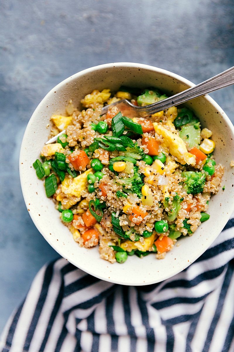 Bowl of quinoa fried rice with colorful vegetables, ready to serve.