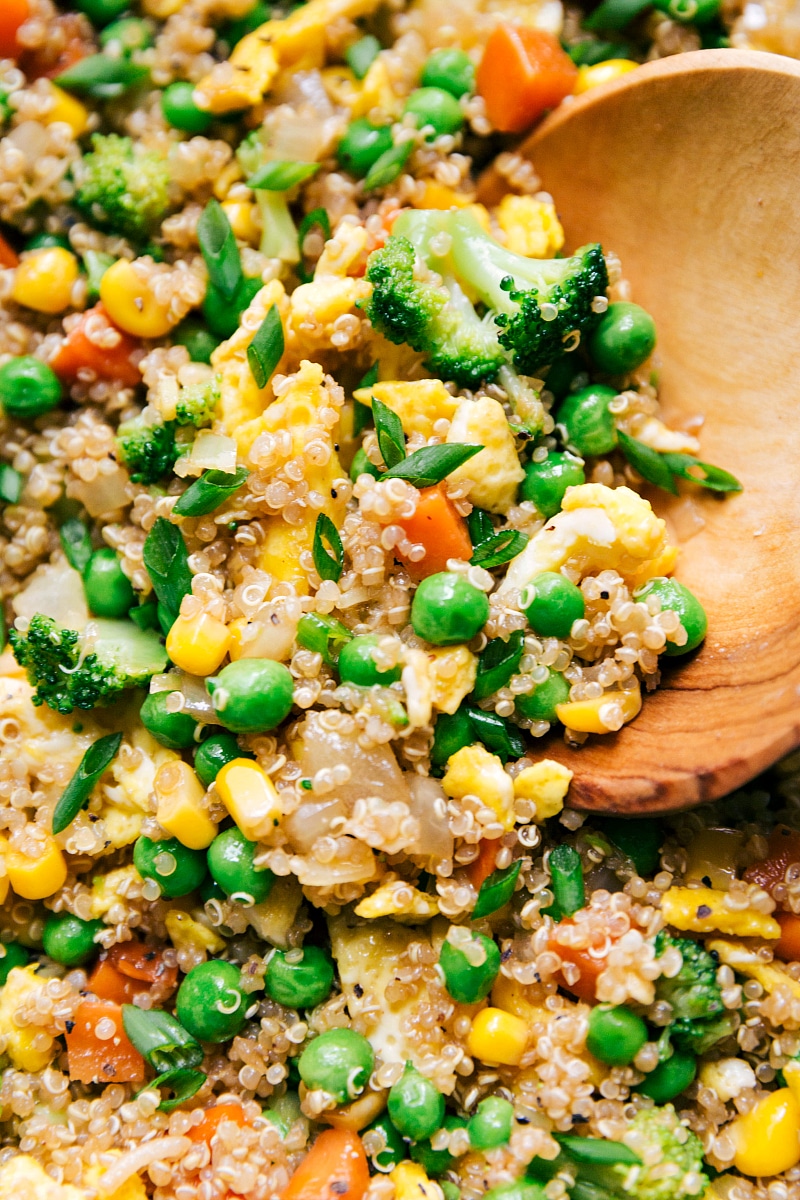 Scoop filled with a hearty serving of quinoa fried rice, showcasing colorful vegetables and quinoa grains.