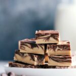 Stacked slices of tiger butter fudge with distinctive chocolate and peanut butter swirls.
