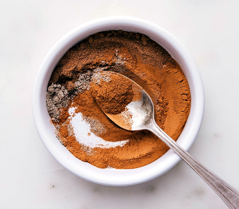 Bowl filled with the aromatic ingredients that make up apple pie spice.