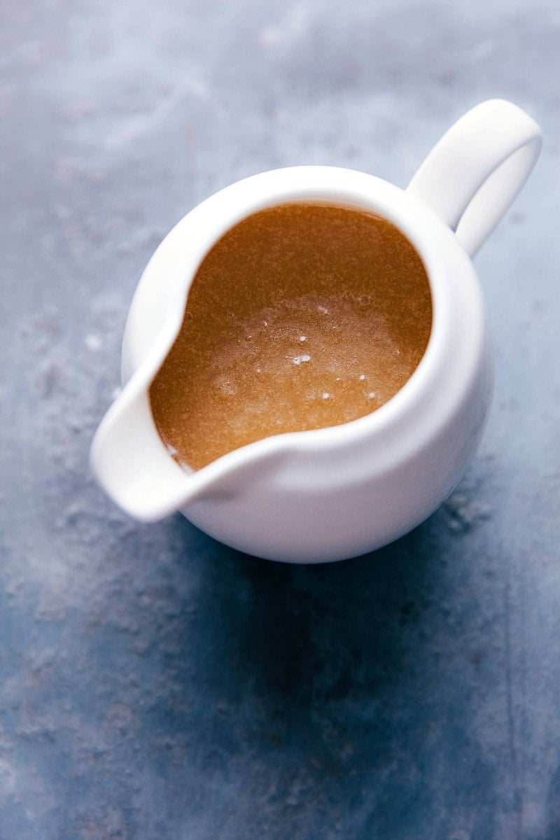 Container filled with creamy buttermilk syrup, with a silky texture, ready to be poured.