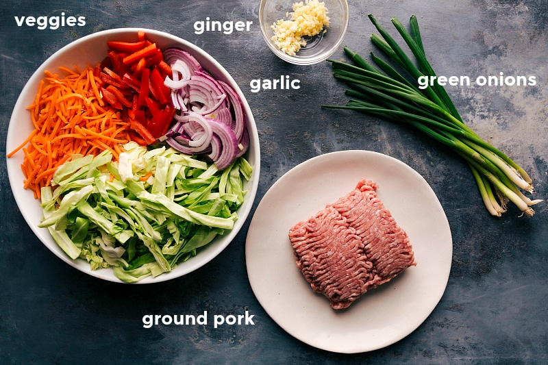 Collection of ingredients for the egg roll in a bowl recipe, including ground meat, vegetables, and seasonings.