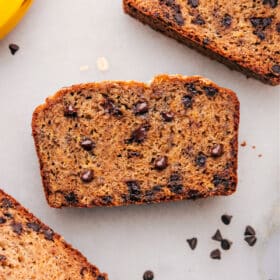 Slices of healthy banana bread, warm and inviting, with chocolate chips scattered throughout.