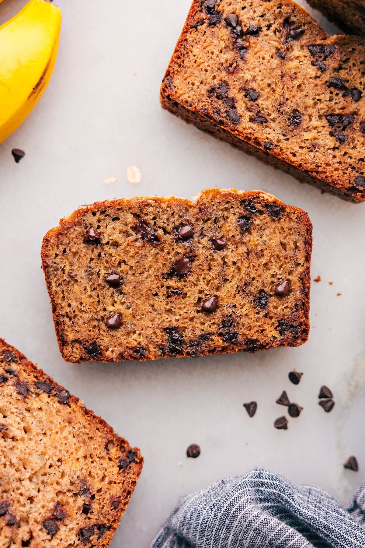 Slices of healthy banana bread, warm and inviting, with chocolate chips scattered throughout.