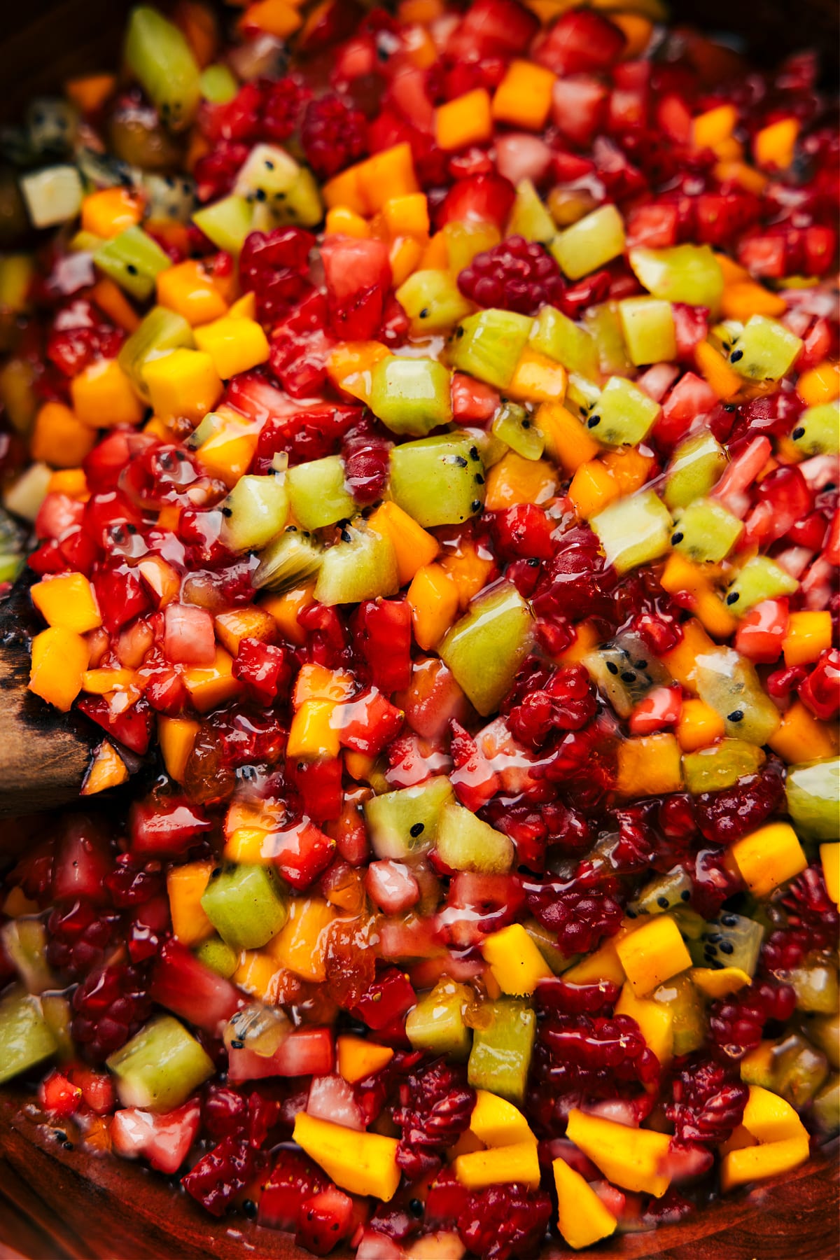 Vaisių salsa dubenyje, paruošta mėgautis su cinamono drožlėmis.