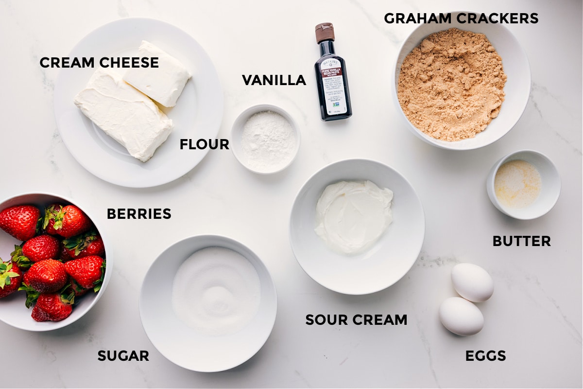 Ingredients In Mini Cheesecake Recipe All the ingredients in this recipe prepped out for easy assembly including the berries, cream cheese, sugar, flour, vanilla, sour cream, eggs, butter, graham crackers, and vanilla.