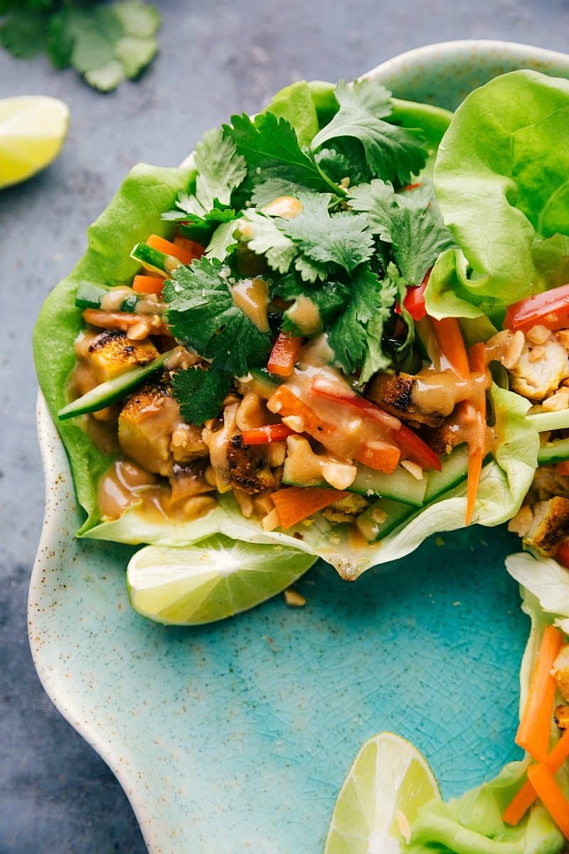 Plate of peanut chicken lettuce wraps, featuring vibrant lettuce cups filled with savory chicken and peanut sauce.