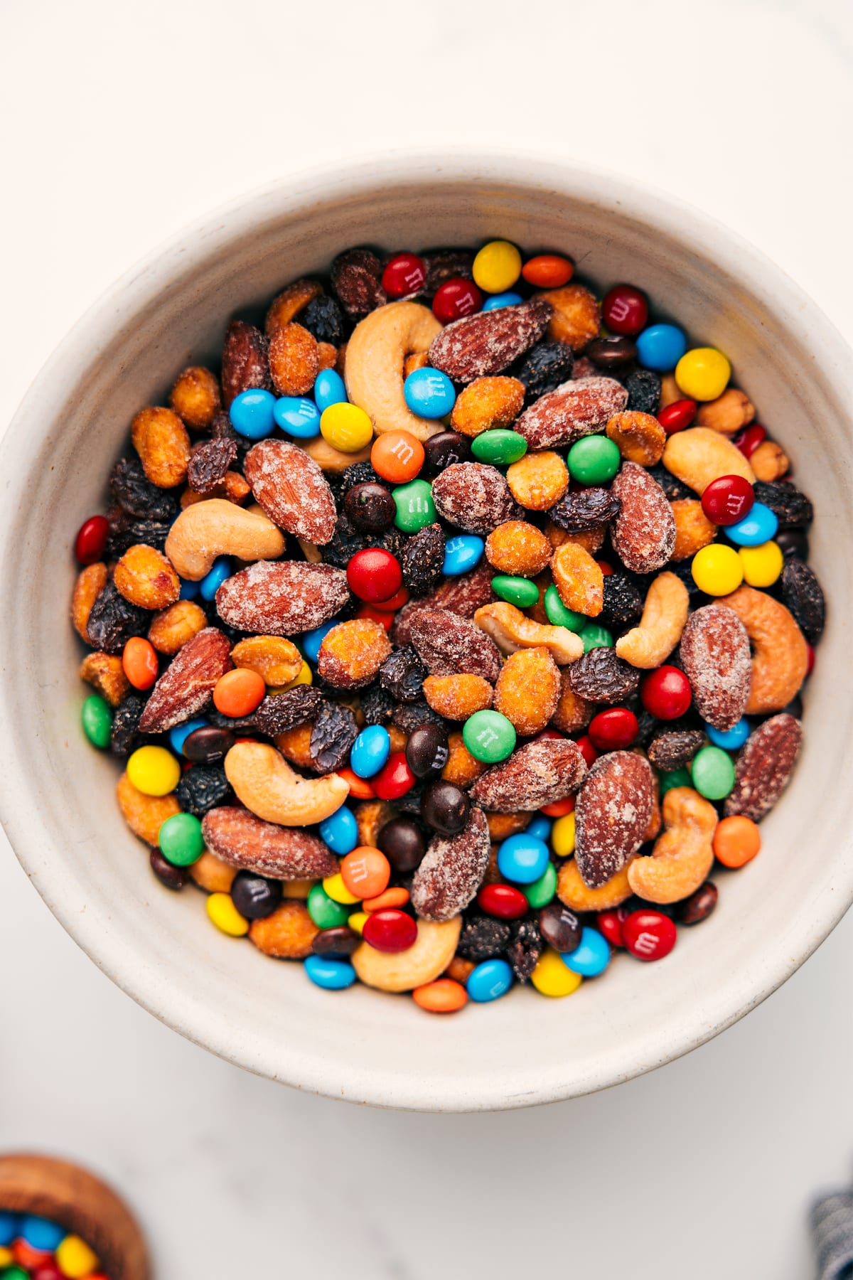 Simple And Delicious Trail Mix Recipe Trail Mix Recipe in a bowl filled with nuts, pretzels, chocolate candies, and dried fruit ready to be enjoyed.