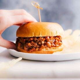 Turkey sloppy joes on a plate, held by a hand, ready to be savored.