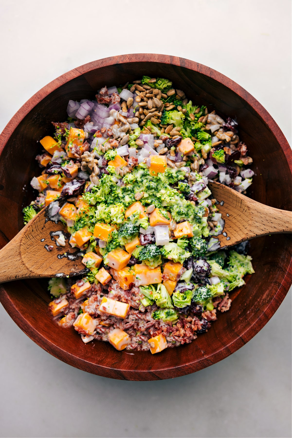 The broccoli salad in a bowl ready to be tossed together.