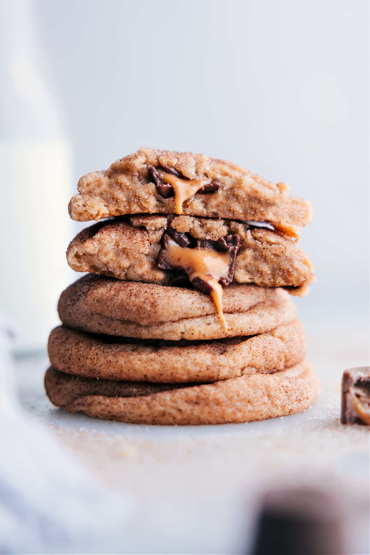 A stack of mouthwatering caramel snickerdoodles with centers oozing with melting caramel and chocolate.